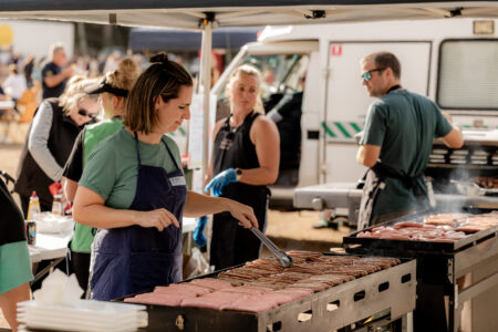 Image of volunteers supporting their School Association in cooking a sausage sizzle